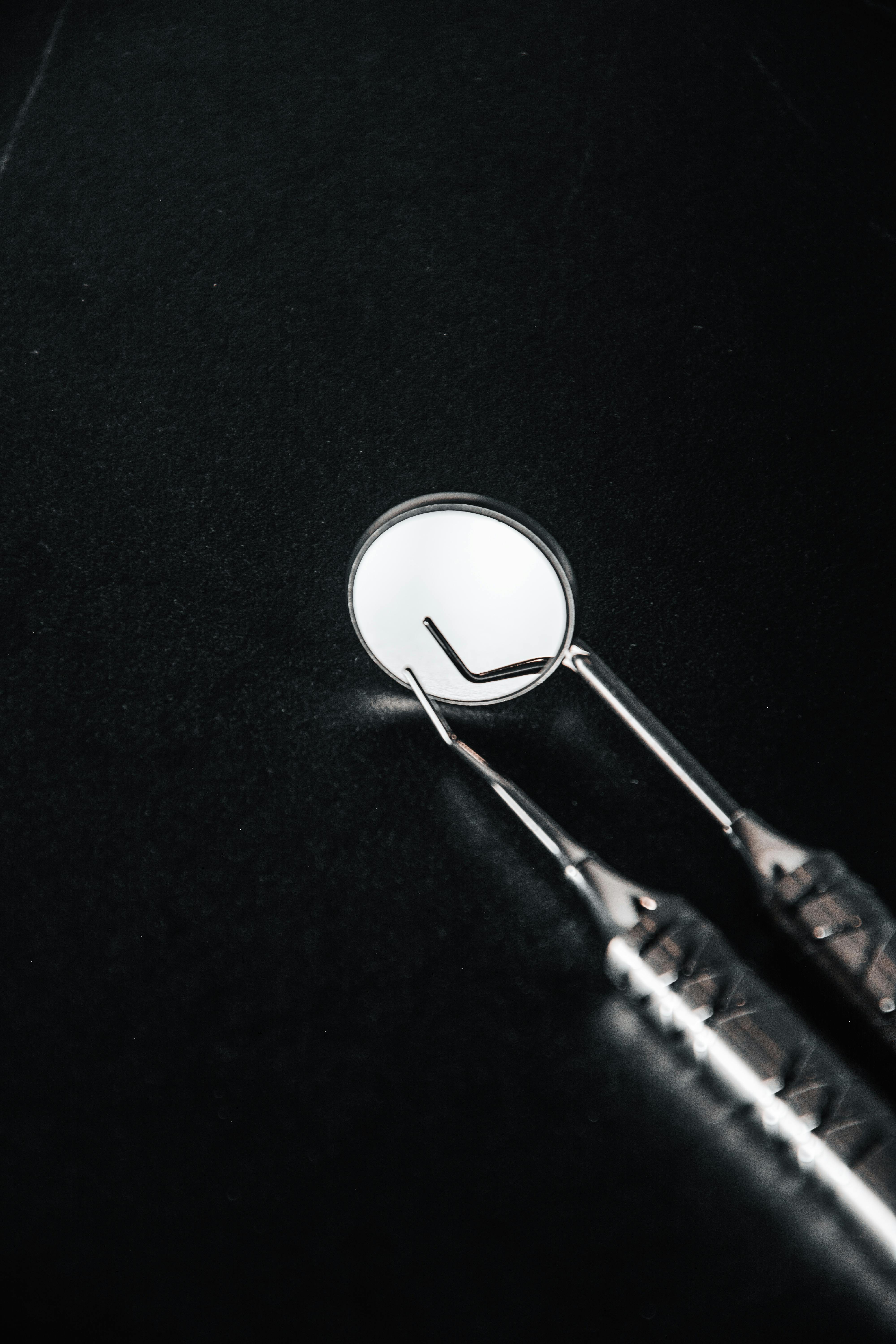 Dental inspection mirror on a dark surface